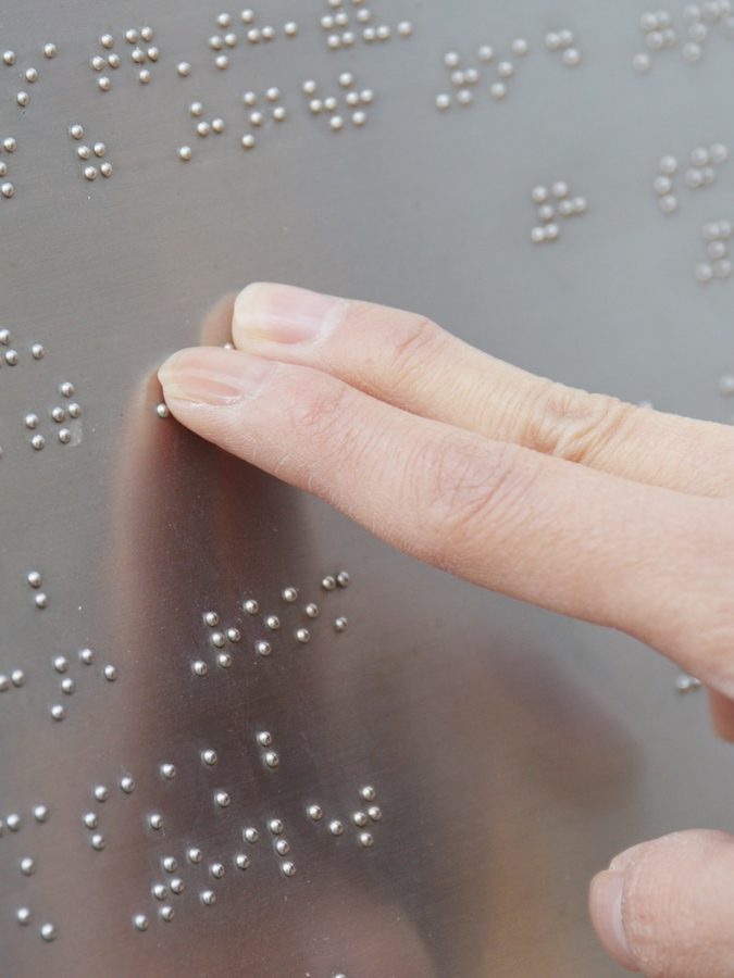 Blind reading on Braille at outdoor directory