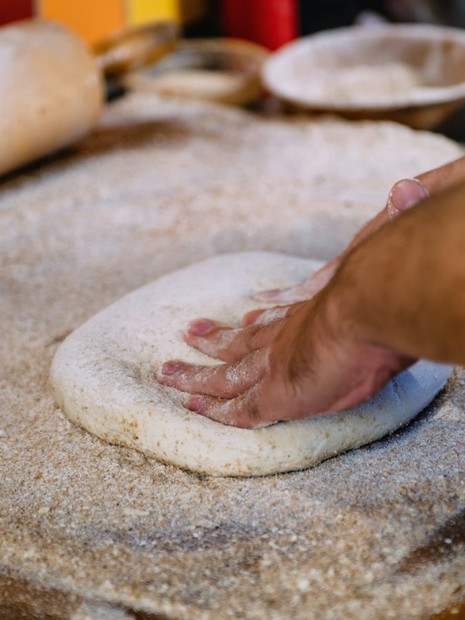 Hands Kneading Dough For Pizza In Bakery Shop