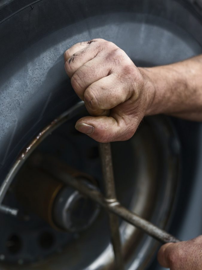 Hands of mature man repairing car